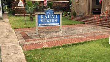 Een bord voor het Kaua'i Museum met een souvenirwinkel, een gebouw van steen en een Amerikaanse vlag.