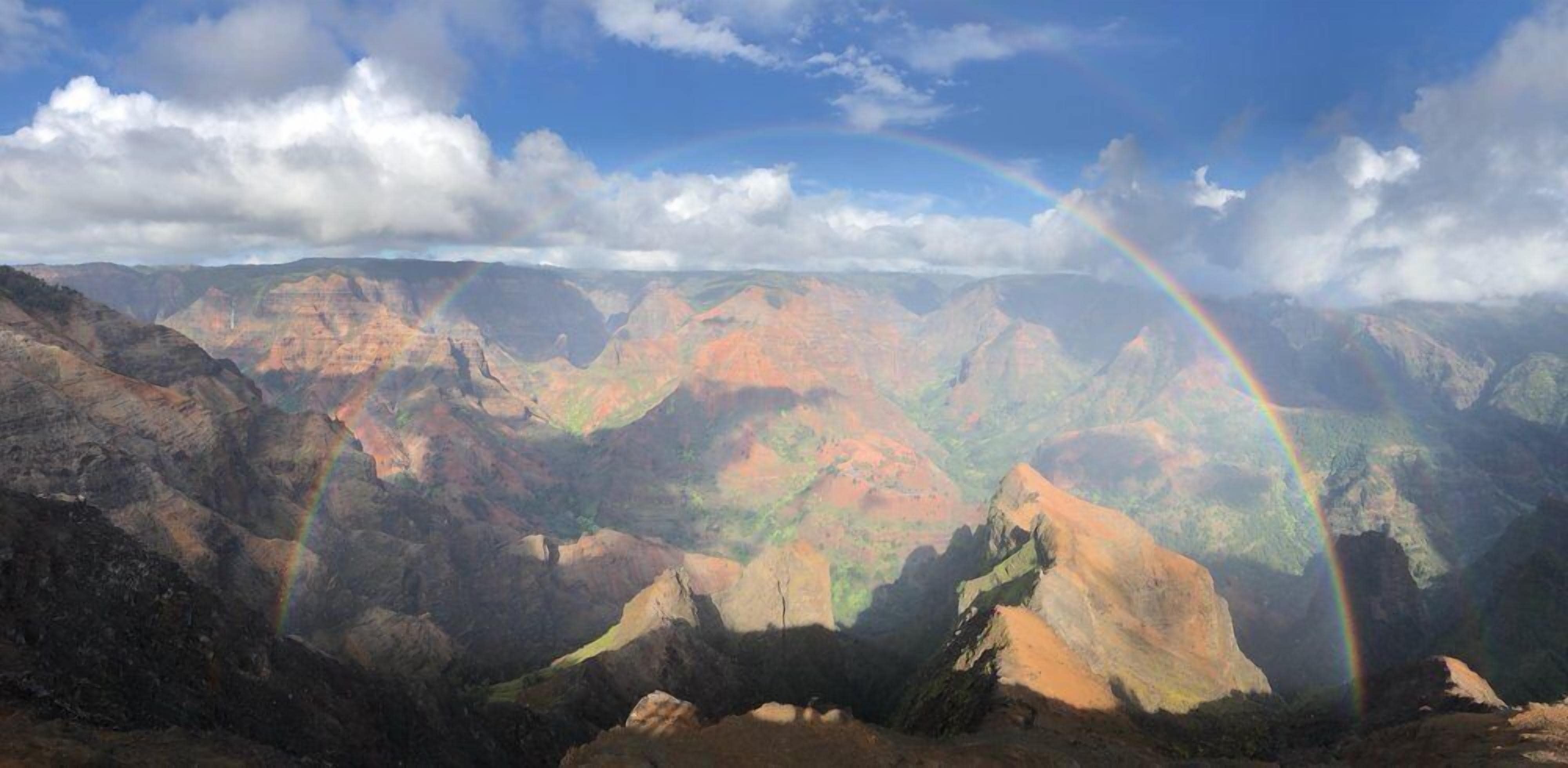 A mountainous landscape with a rainbow.