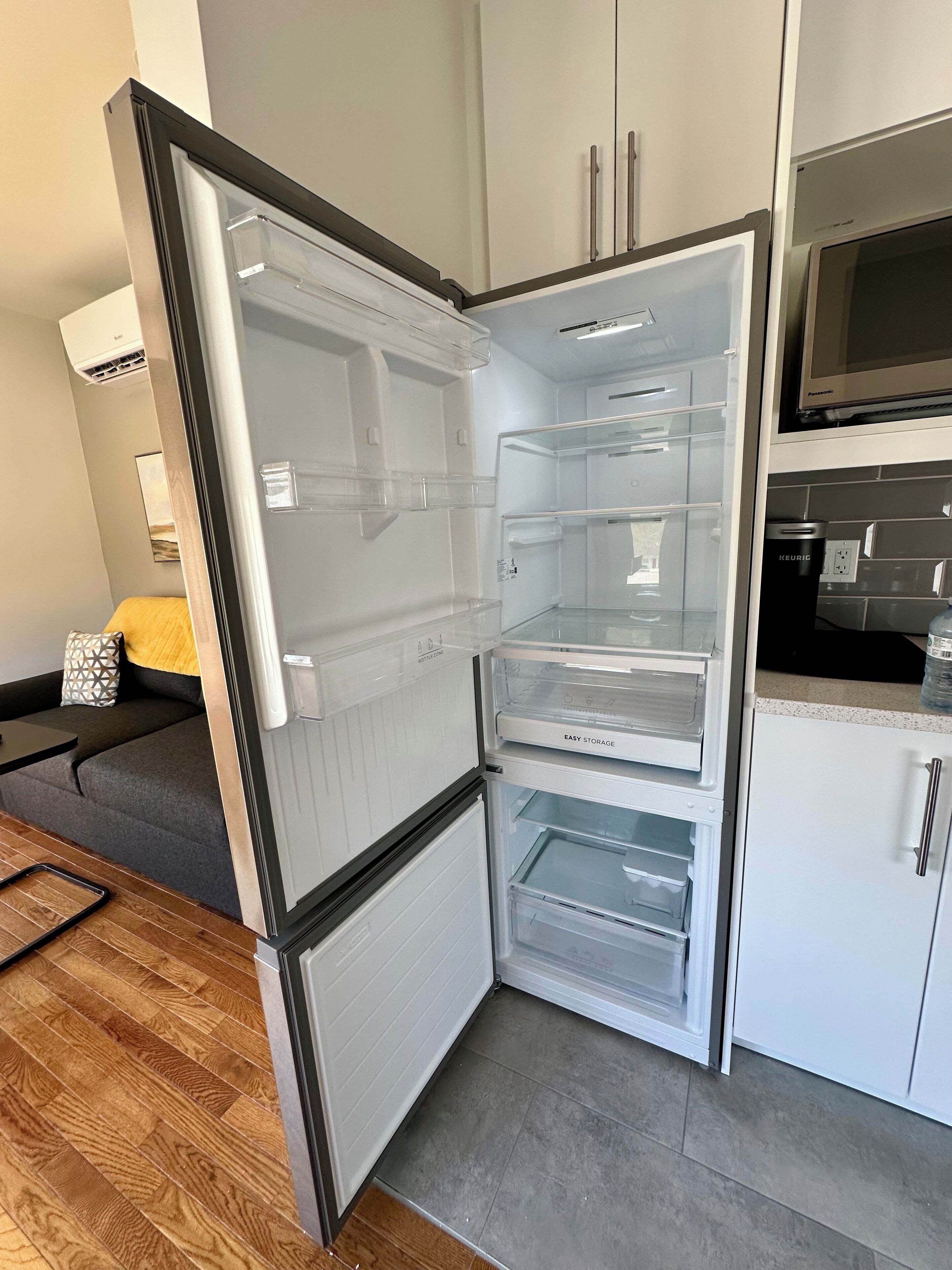 A compact kitchen with a built-in refrigerator, a microwave, and a sink.