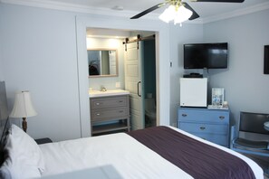 A hotel room with a bed, a desk, a chair, a television, a mirror, and a wardrobe. - Motel Le Refuge (Sherbrooke)