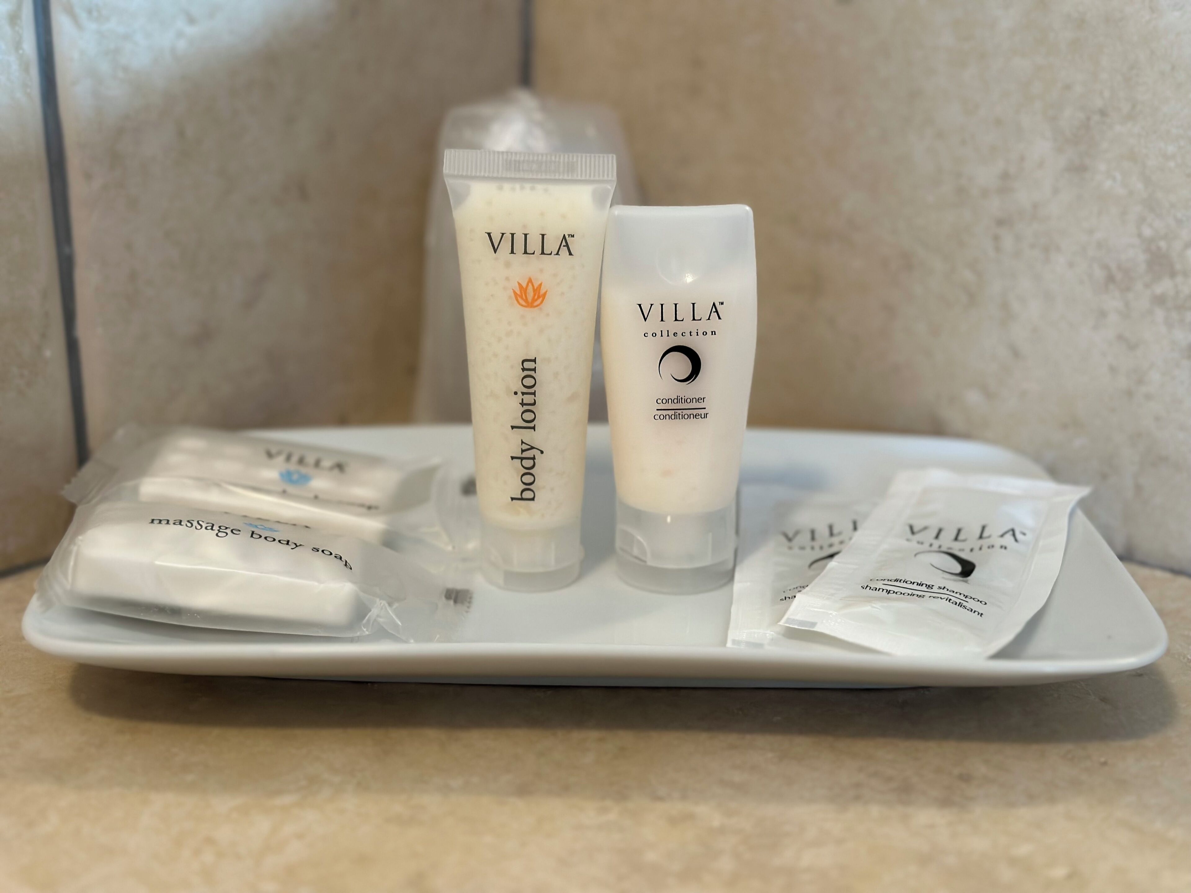 A tray with various Villa brand toiletries including body lotion, conditioner, and massage body soap.