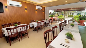 A restaurant with wooden panel walls, white tablecloth-covered tables, and chairs. - Hotel Azuan Suites By Geh Suites (Cartagena)