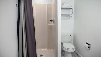 Ein modernes Badezimmer mit Dusche, Toilette und Handtuchhalter.