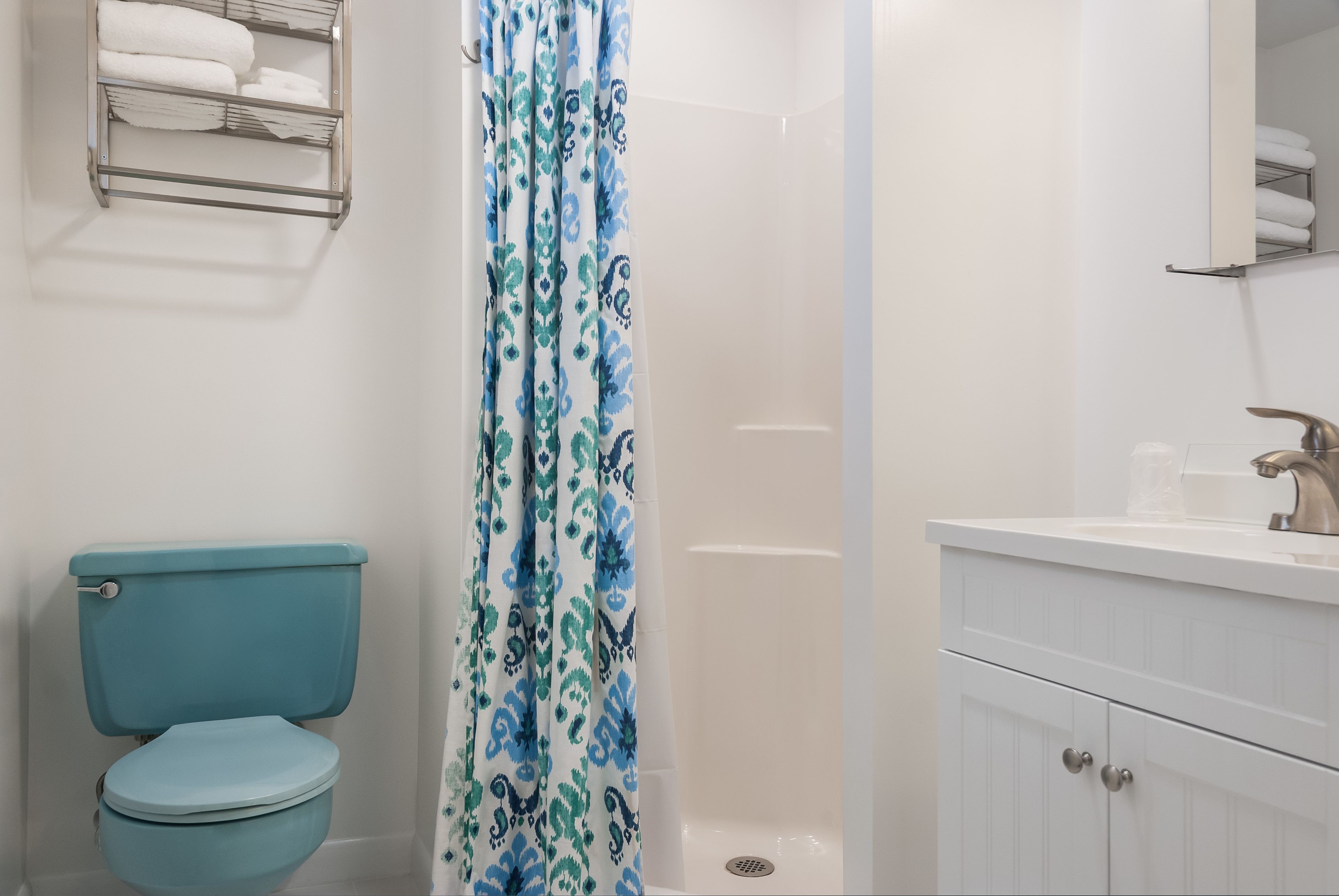 Une salle de bain avec des toilettes, un rideau de douche et un lavabo avec un miroir au-dessus.