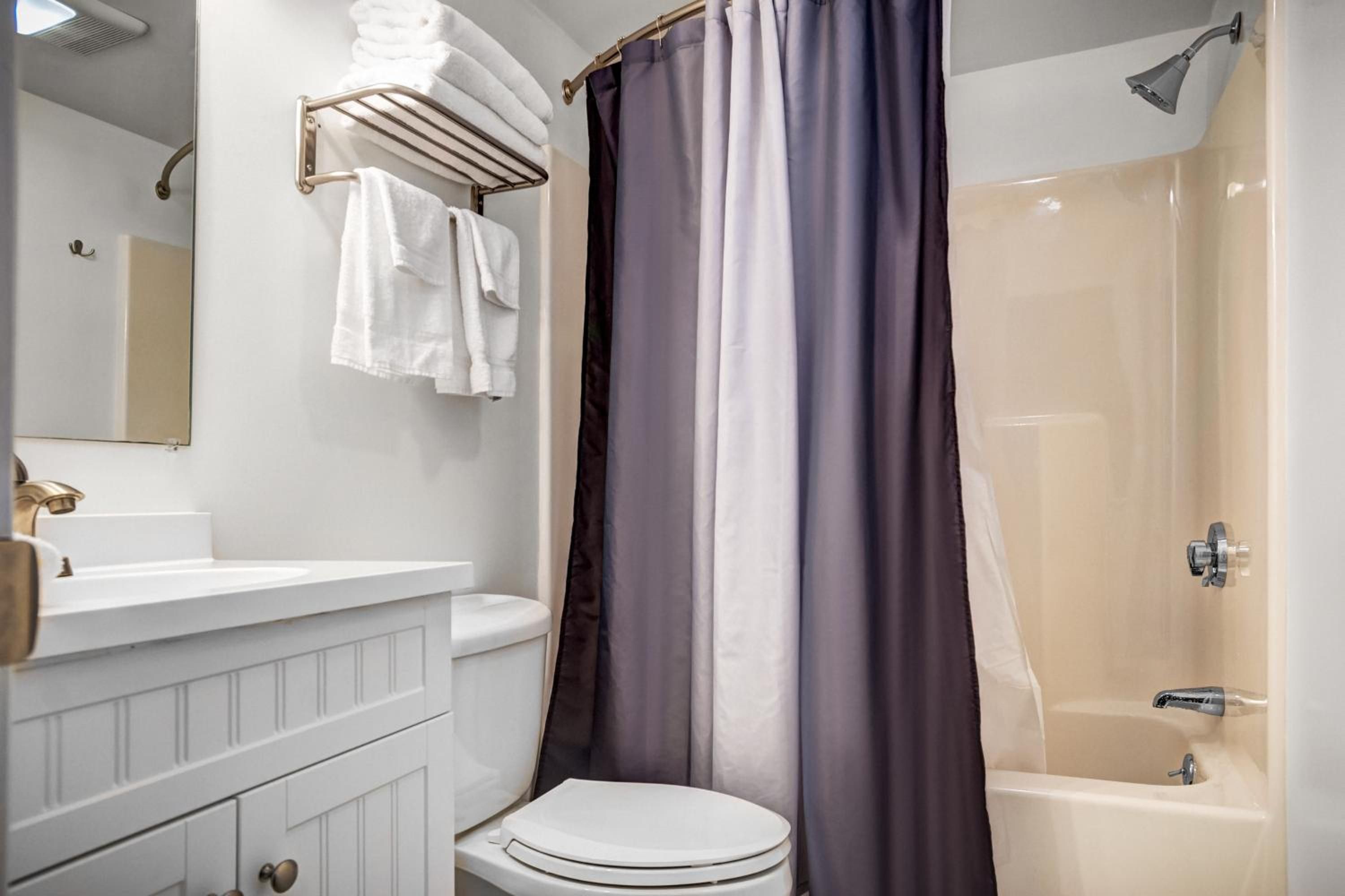 A bathroom with a toilet, sink, and shower.