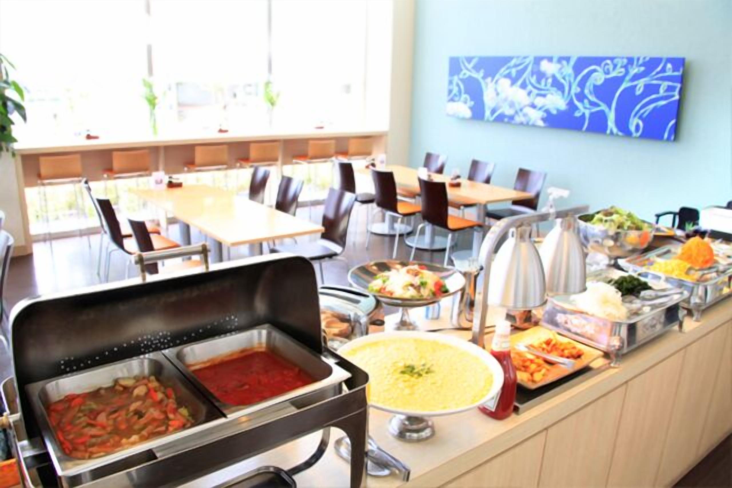 A buffet area with various food options, including pasta, salads, and a soup station.