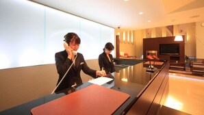 Un moderno hall de hotel con mostrador de recepción, mesa de billar y televisión.