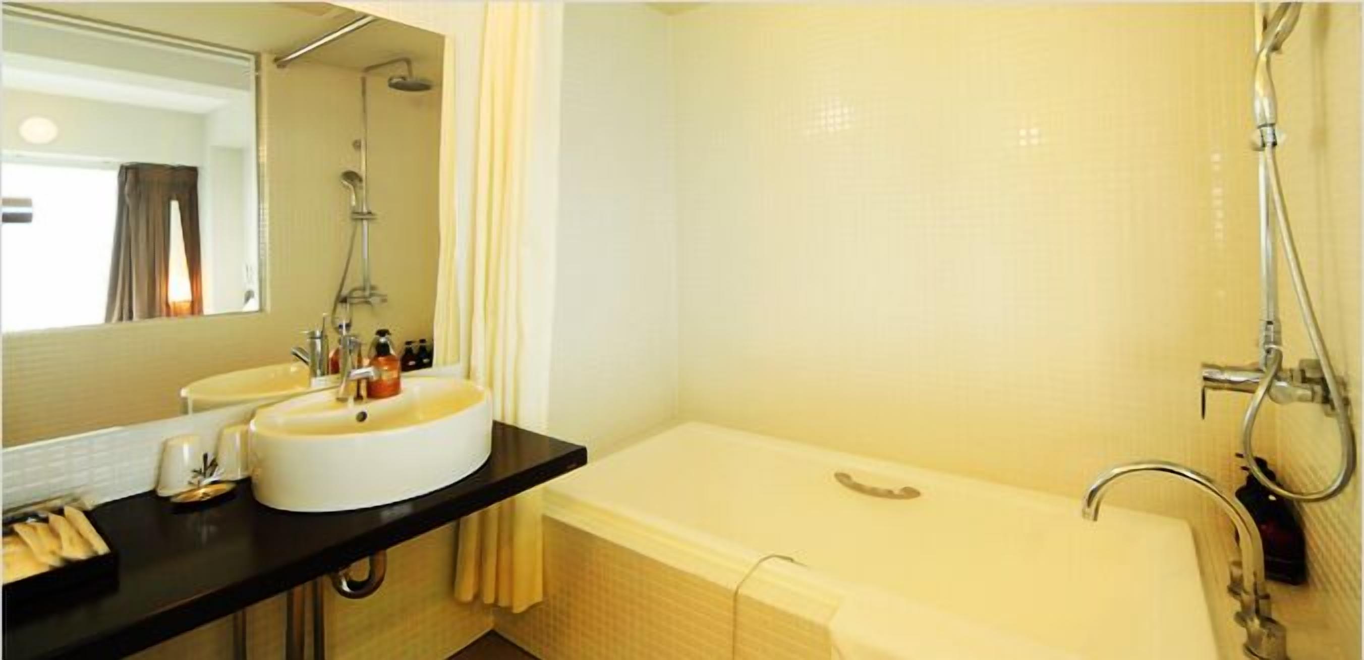 A bathroom with two sinks, a bathtub, and a shower.