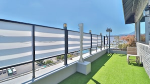 Un balcon donnant sur une route et une piscine.