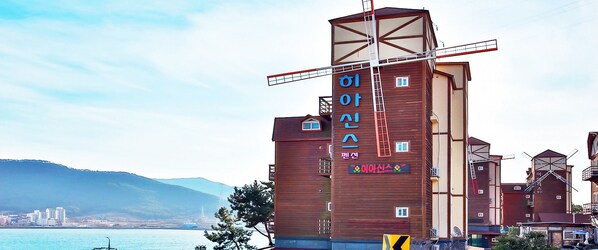 A building with a windmill structure and signage in a foreign language.