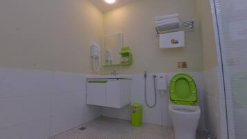 Un baño con inodoro, lavabo, espejo, toallero y un cubo de basura.
