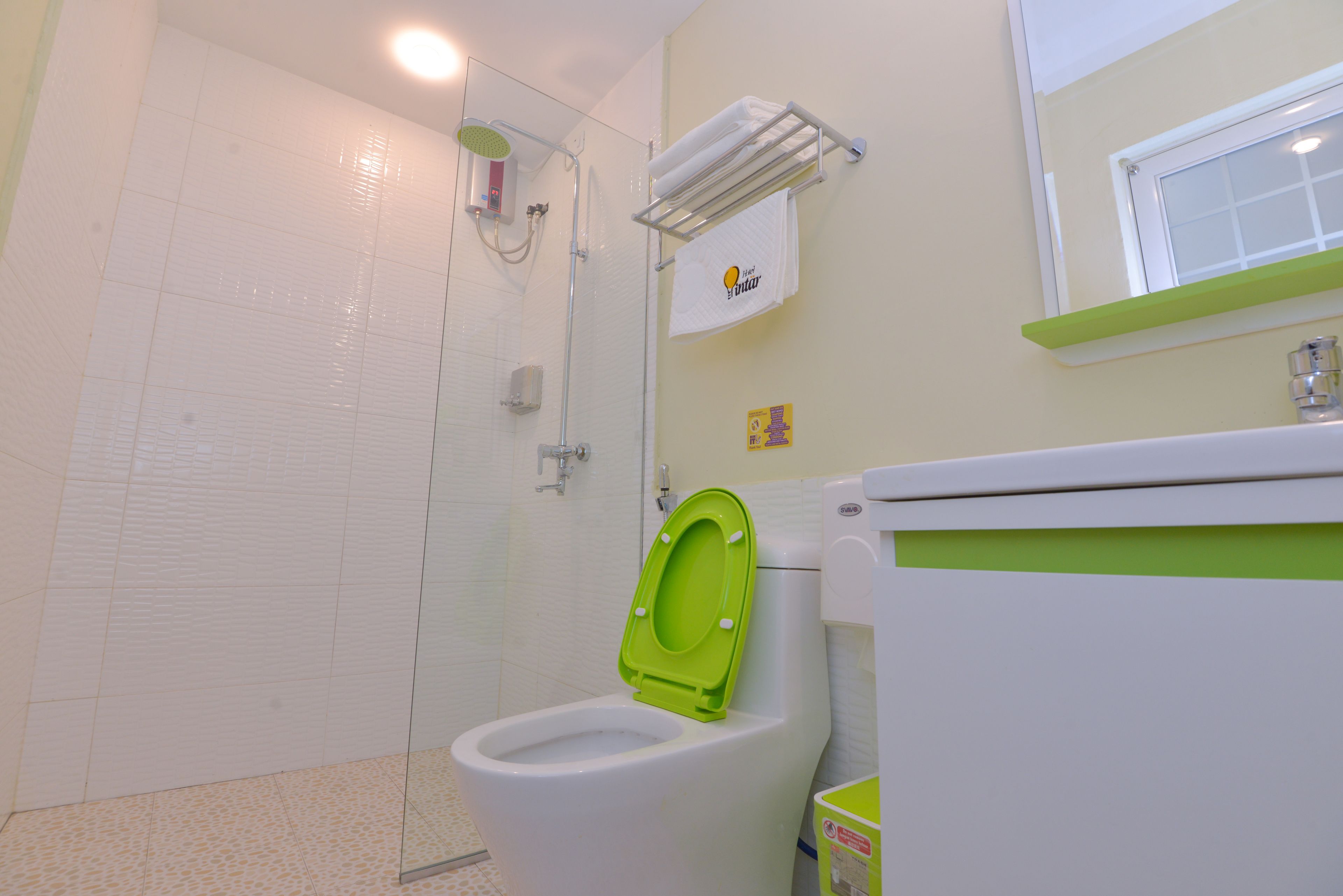 A bathroom with a shower, toilet, and a towel rack.