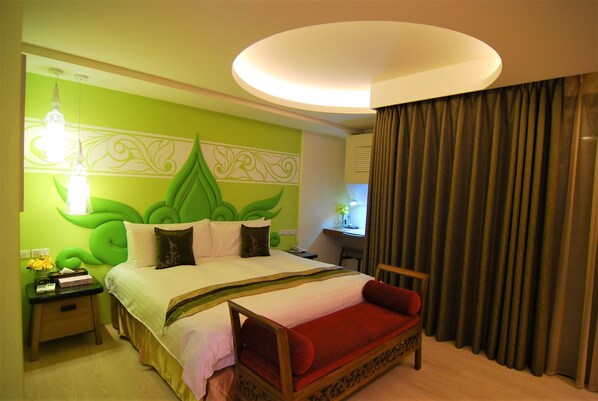 A hotel room with a large bed, a desk, and a chair.