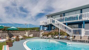 Relax by the pool surrounded by lounge chairs and umbrellas.