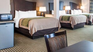 A hotel room with two beds, each with a headboard, bedside lamps, and a flat-screen TV on a stand. - Comfort Inn & Suites Woodward (Woodward)