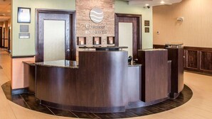 A hotel reception desk with a sign reading "Comfort Inn & Suites." - Comfort Inn & Suites Woodward (Woodward)