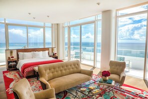 A hotel room with a large bed, a sofa, a chair, and a view of the ocean. - Faena Miami Beach (Miami Beach)