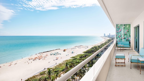 A balcony with a view of a beach and ocean.
