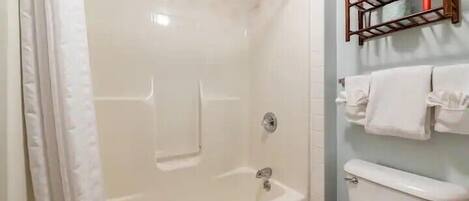 Un baño con bañera, inodoro y perchero para toallas.