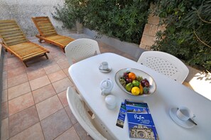 Enjoy a romantic meal for two on the patio, surrounded by lush greenery and a serene atmosphere.