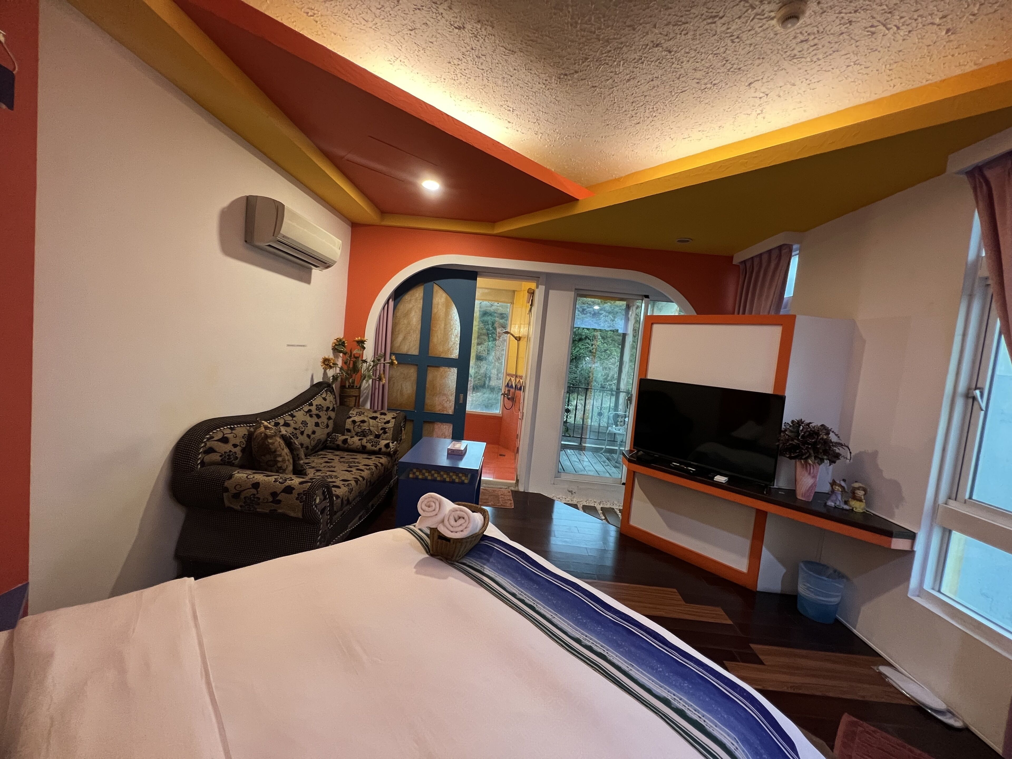 Una habitación de hotel con sofá, un mueble para televisor y cama.