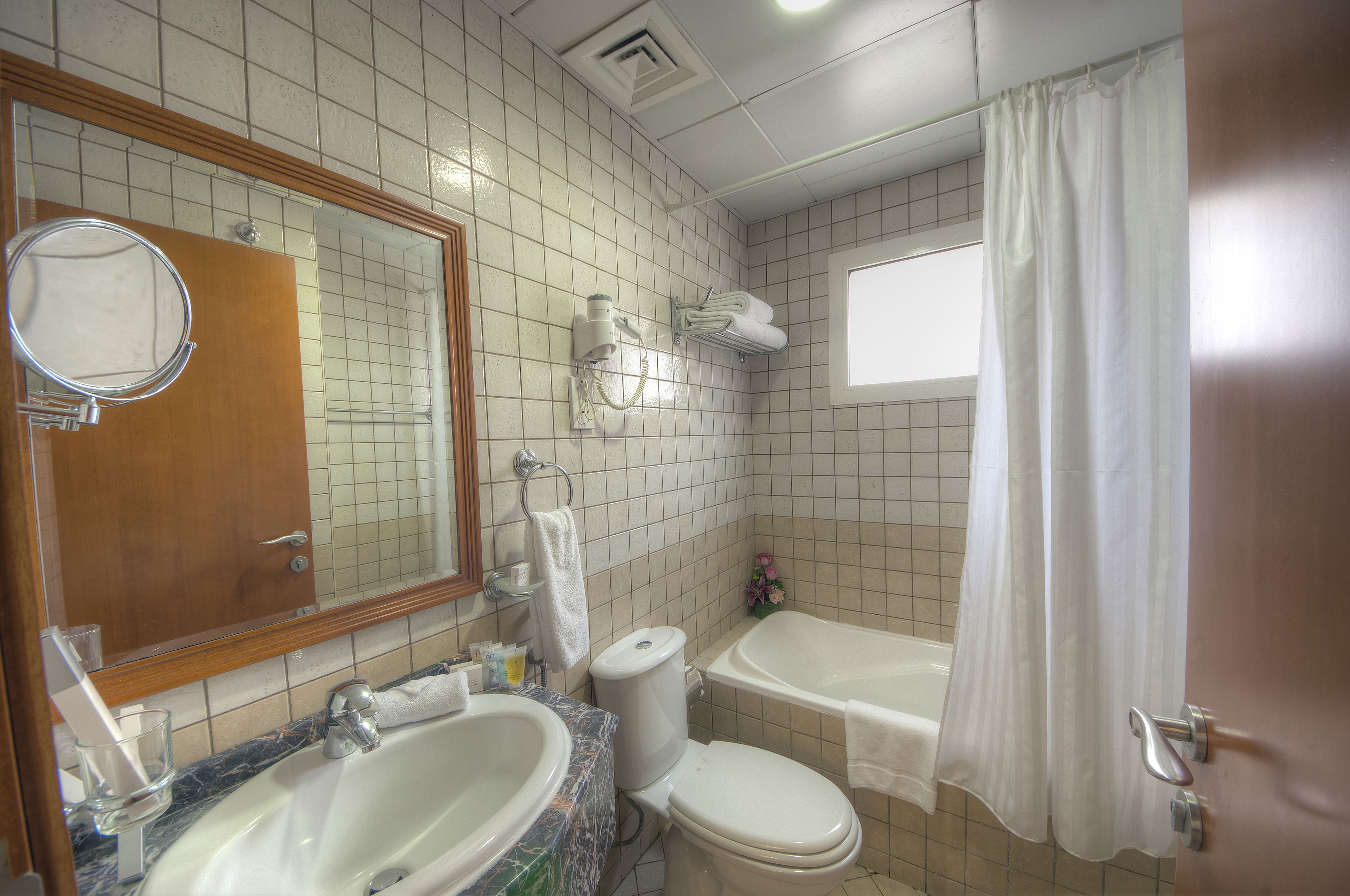 Une salle de bain avec un lavabo, des toilettes et une baignoire, le tout en marbre.