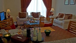 A hotel room with two sofas, a coffee table, and a TV. - La villa Najd Hotel Apartments (Dubai)