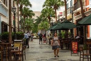 A cobblestone street lined with palm trees and outdoor seating areas. - ibis Rio de Janeiro Shopping Nova America (Rio de Janeiro)