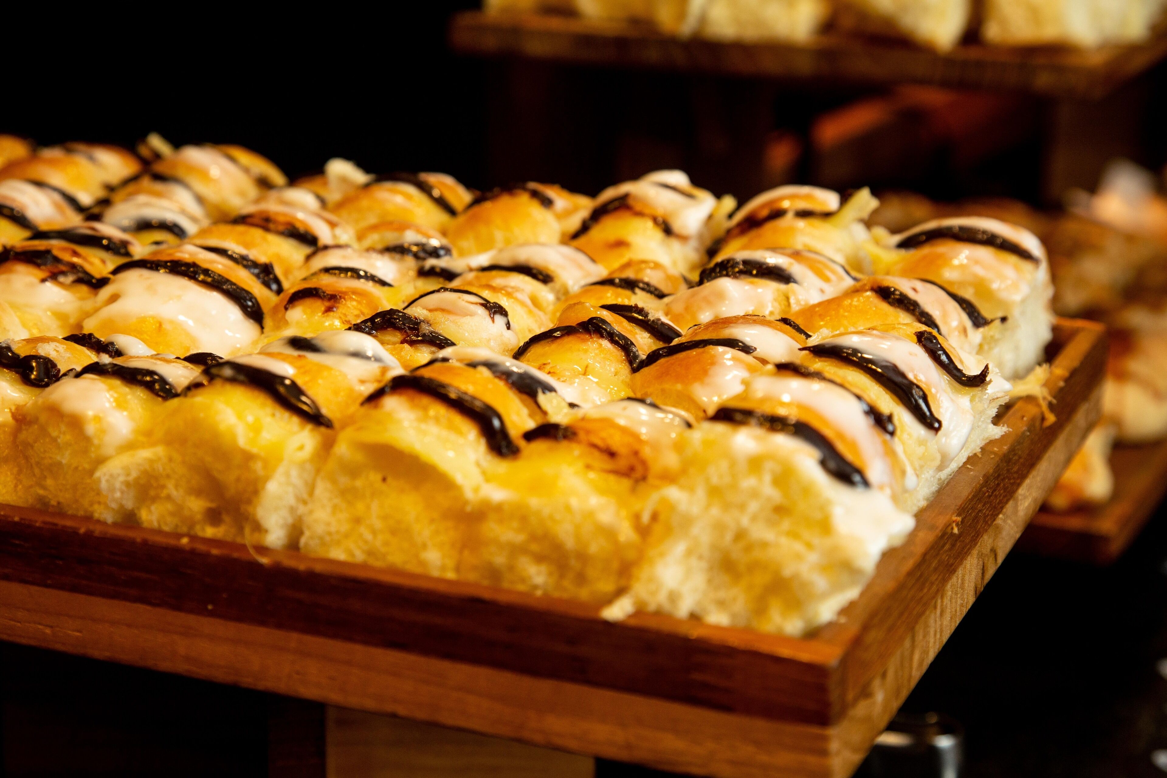 A tray of pastries with chocolate drizzle.