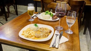A dining table with plates of food and glasses of wine.