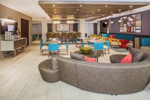 A modern hotel lobby with a seating area, a coffee shop, and a bar. - Holiday Inn Express & Suites Litchfield West by IHG (Litchfield)