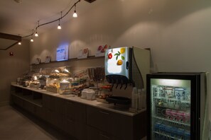 A buffet area with a refrigerator displaying fruit images, a beverage dispenser, and various food containers. - Holiday Inn Express & Suites Litchfield West by IHG (Litchfield)