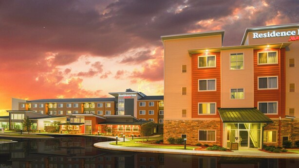A hotel with multiple buildings, a well-lit entrance, and a reflection in the water. - Residence Inn Augusta (Augusta)