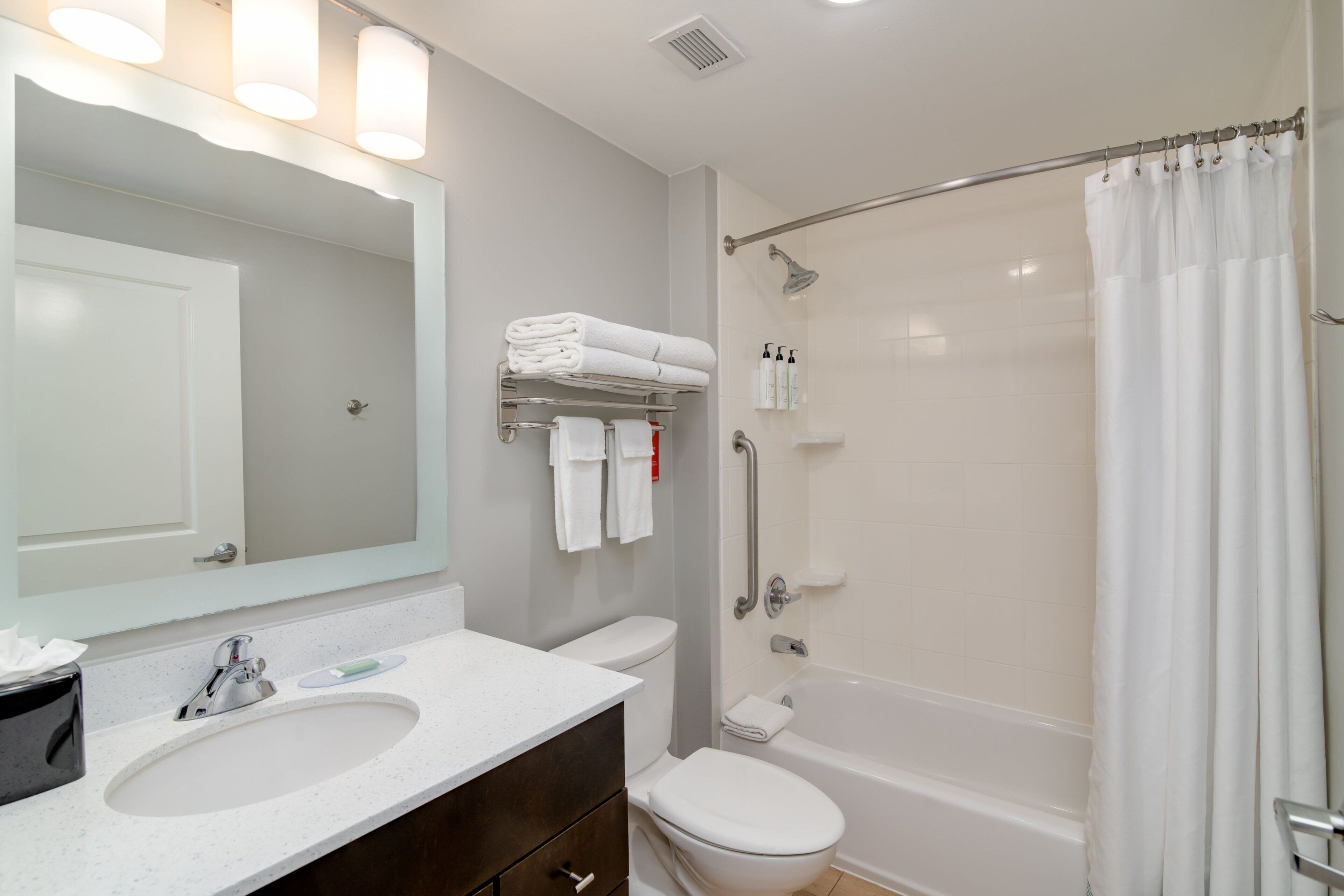 A modern bathroom with a white sink, a toilet, a bathtub, and a shower.