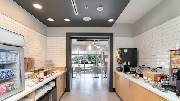A modern kitchen with white tiled walls, stainless steel appliances, and a clean, organized layout. - TownePlace Suites Dallas McKinney (McKinney)