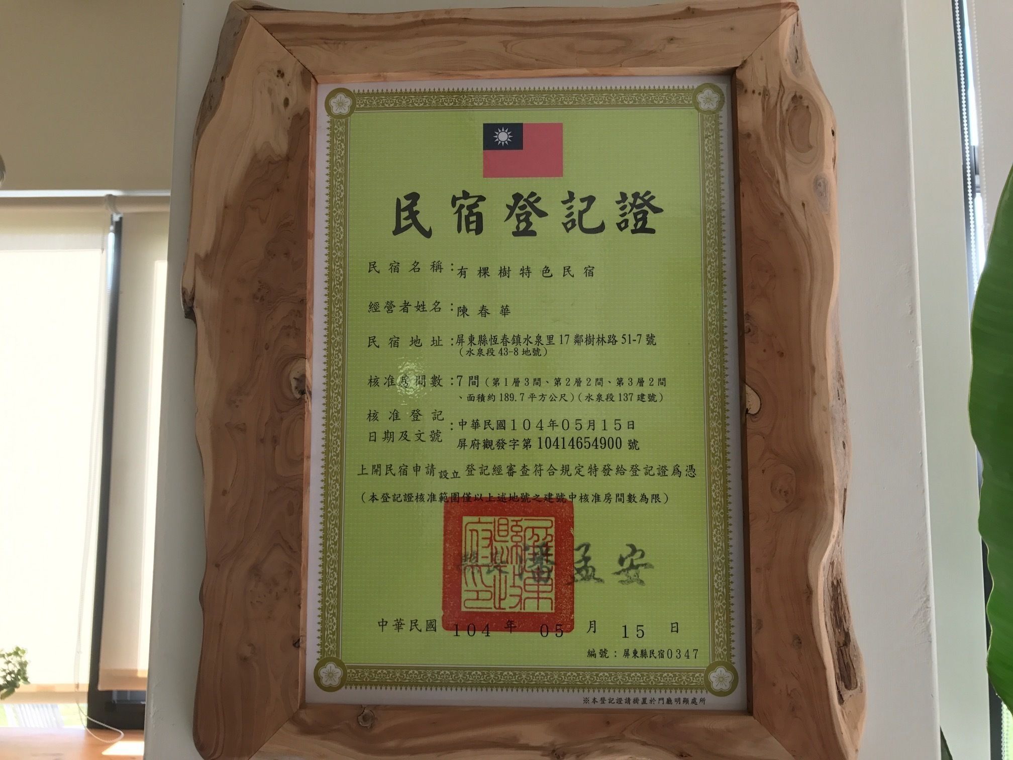 A framed certificate with text in Chinese, including details like the name of the establishment, address, and registration date.