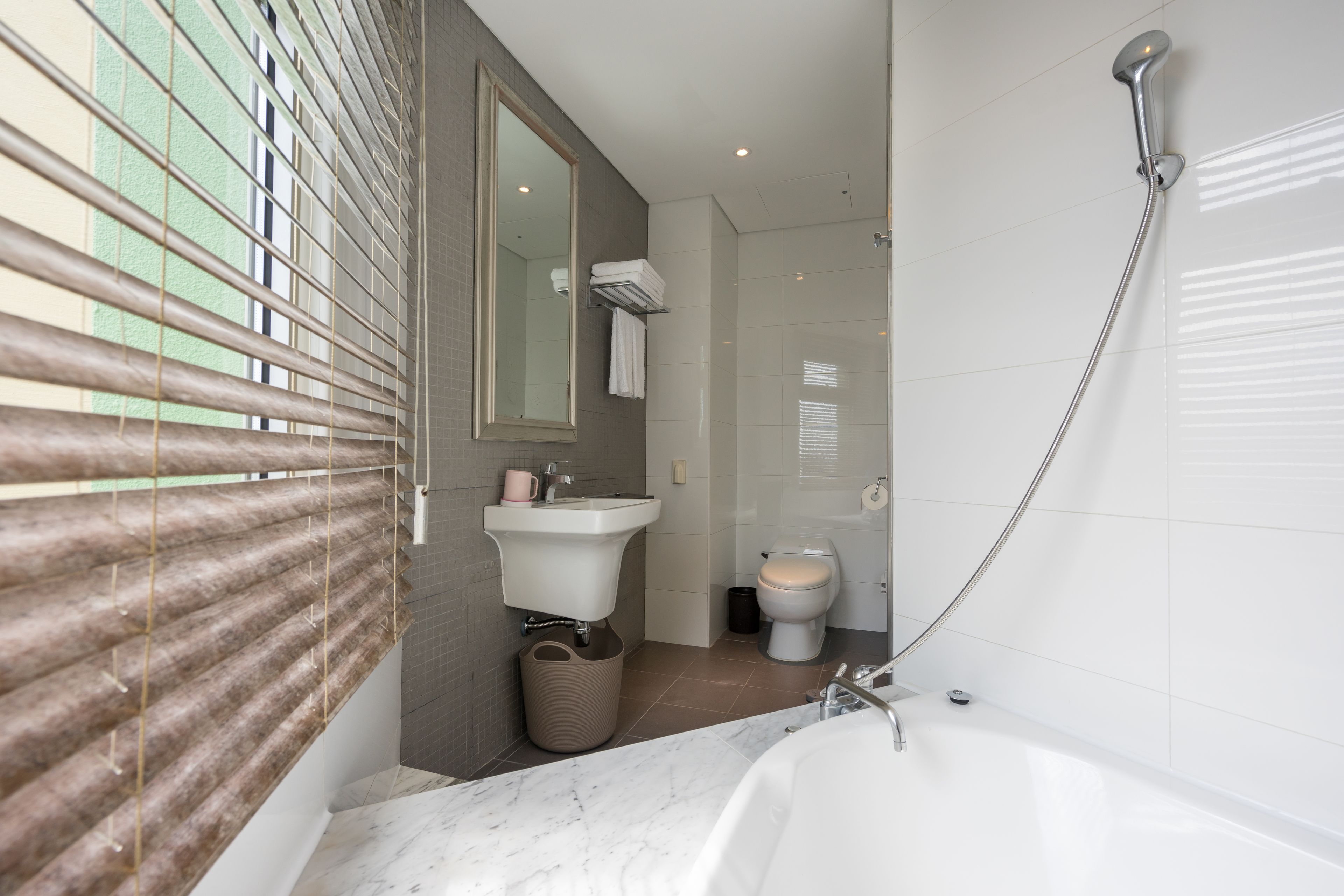A modern bathroom with a bathtub, a sink, and a toilet.