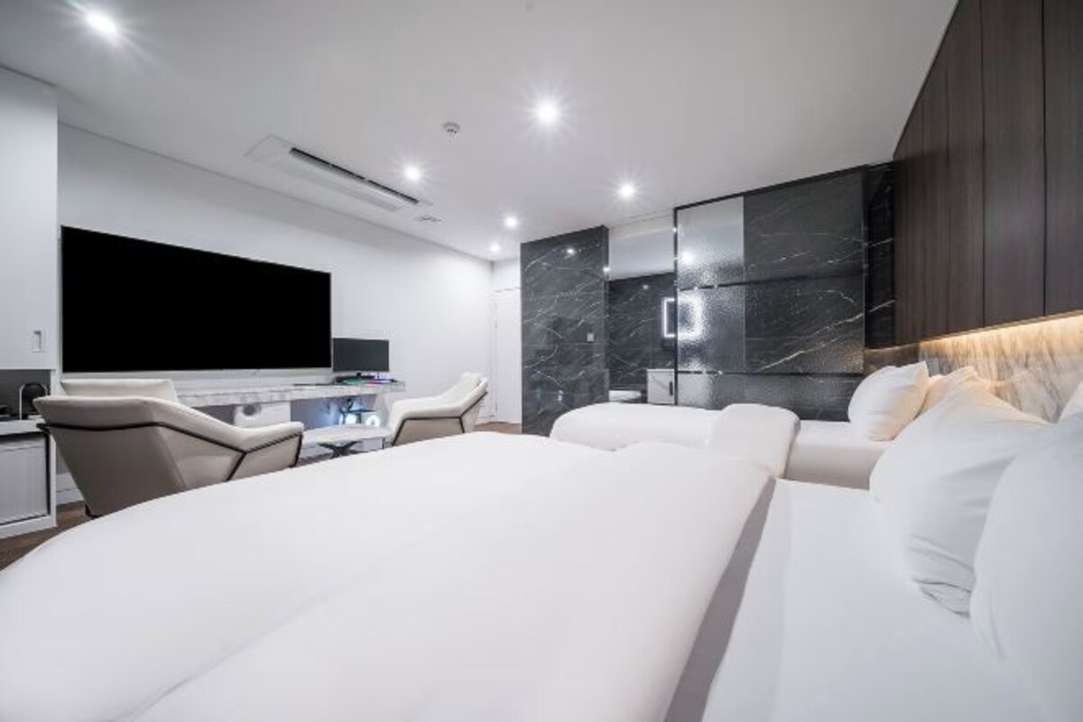 Une chambre d’hôtel moderne, dotée d’un grand lit, d’un bureau et d’une télévision.