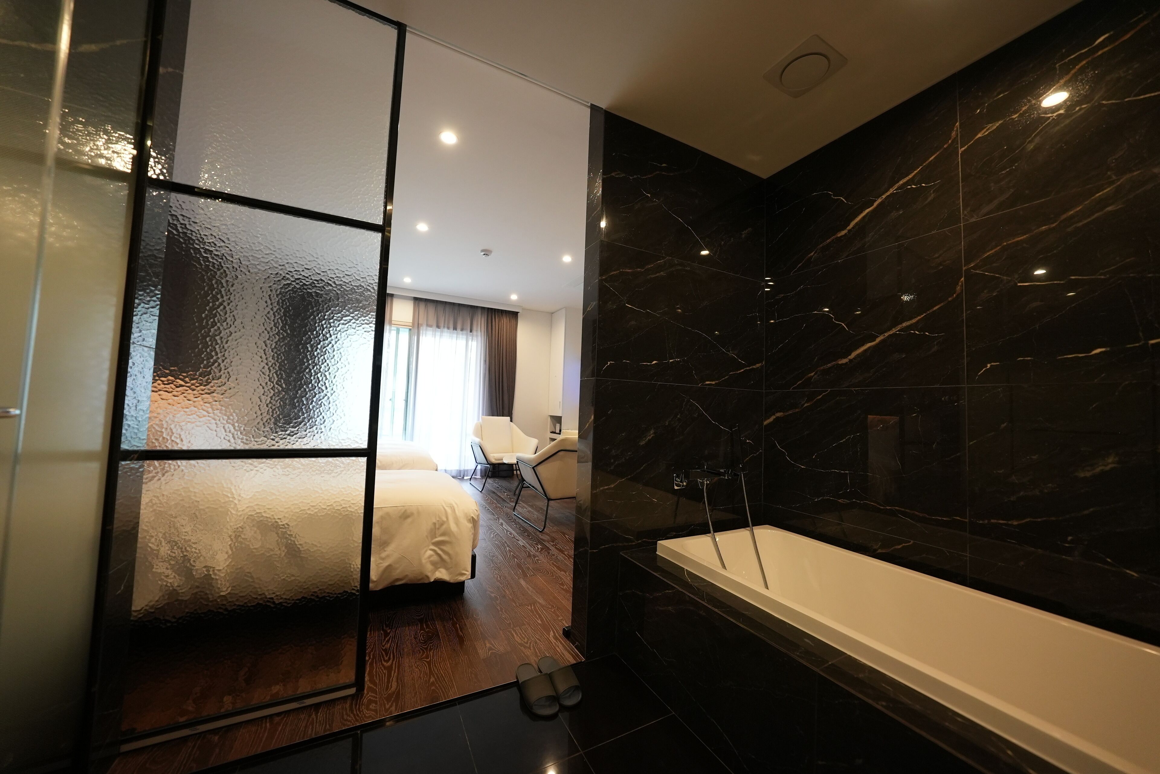 Une salle de bain moderne dotée d’une grande baignoire et d’un espace douche séparé.