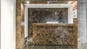 Una zona de recepción con mostrador de mármol y un cartel que dice 'The Best'.