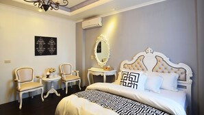 A bedroom with a large bed, two chairs, a small table with a candle, and a mirror on the wall. - Yunju Hotspring Villa (Jiaoxi)