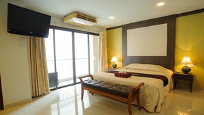 A hotel room with a bed, a bench, a TV, an air conditioner, and two lamps. - Diamond City Place (Pattaya)