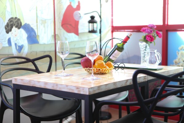 Une table avec deux verres à vin, une bouteille de champagne, un panier de fruits et une carafe.