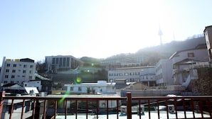 A view of a cityscape with buildings and a tower in the distance. - WELL PLUS BNB Guest House (Seoul)