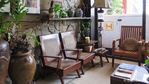 A cozy room with wooden furniture, a stone wall, and various decorative items.