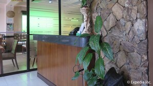 A reception area with a stone wall, a receptionist desk, and a 'No Smoking' sign.