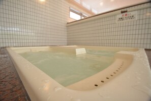 Un jacuzzi con una pared de azulejos al fondo.