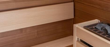 A wooden sauna with a bench and a wall-mounted light fixture.