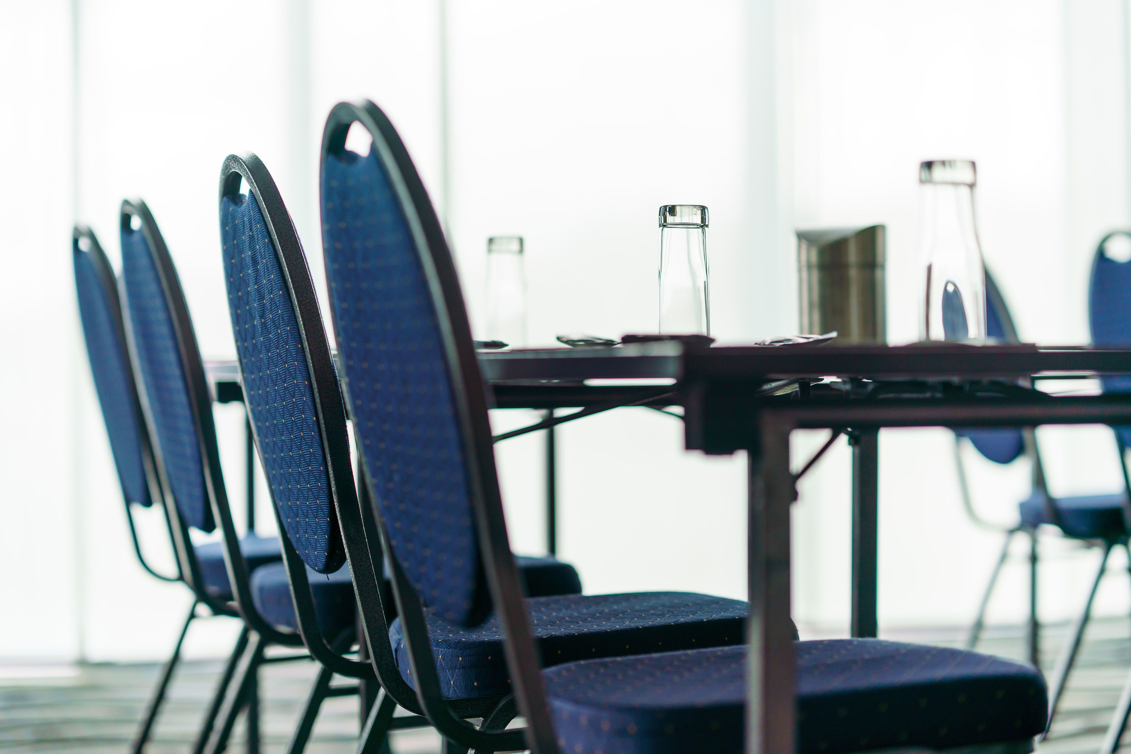 Une salle de conférence avec une longue table et des chaises.