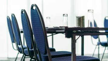 Une salle de conférence avec une longue table et des chaises.
